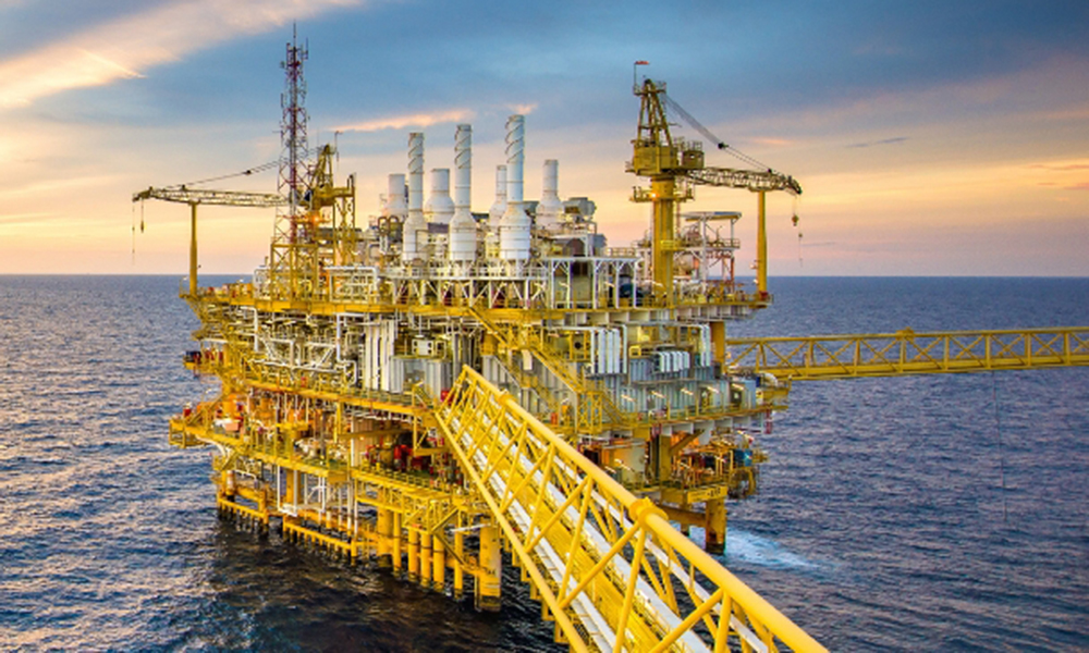Offshore oil and gas platform at sunset, representing Momentive high-performance additives for upstream drilling, completion, and production operations.