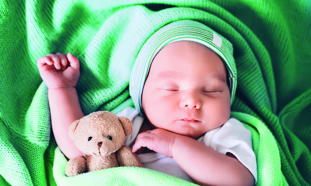 Baby wearing and laying on several types of green fabrics treated with low cyclics silicone solutions for eco-friendly textile finishing.