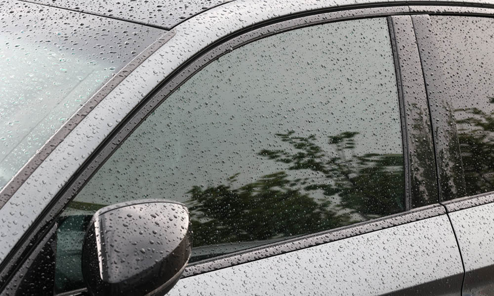 It's raining on a dark colored car. Heavy rain