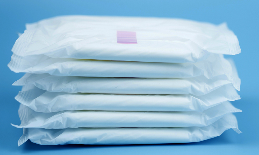 Stacked sanitary napkin pad on blue background.