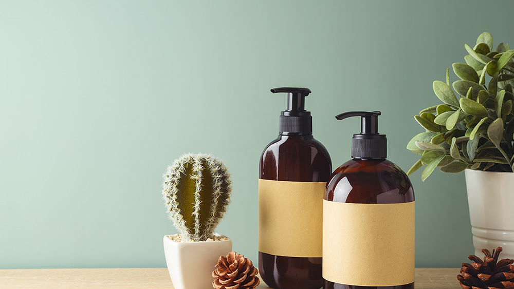 Natural beauty SPA cosmetics bottles with labels for mock up packaging design on wooden table over green background.