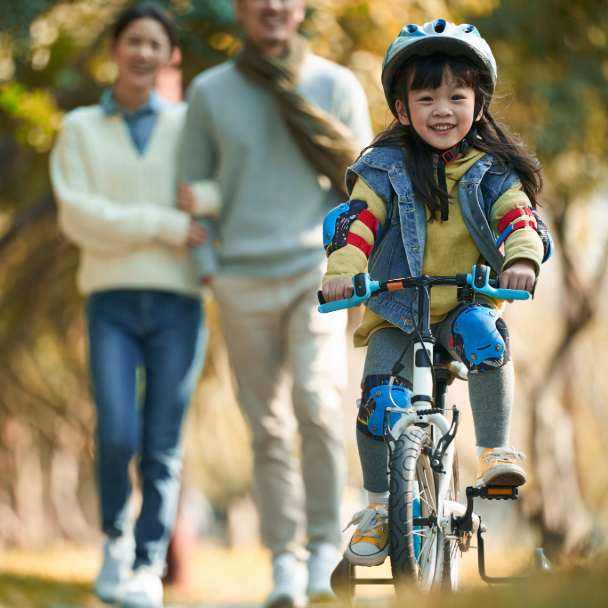 Family Enjoying Daughter Riding a Bicycle