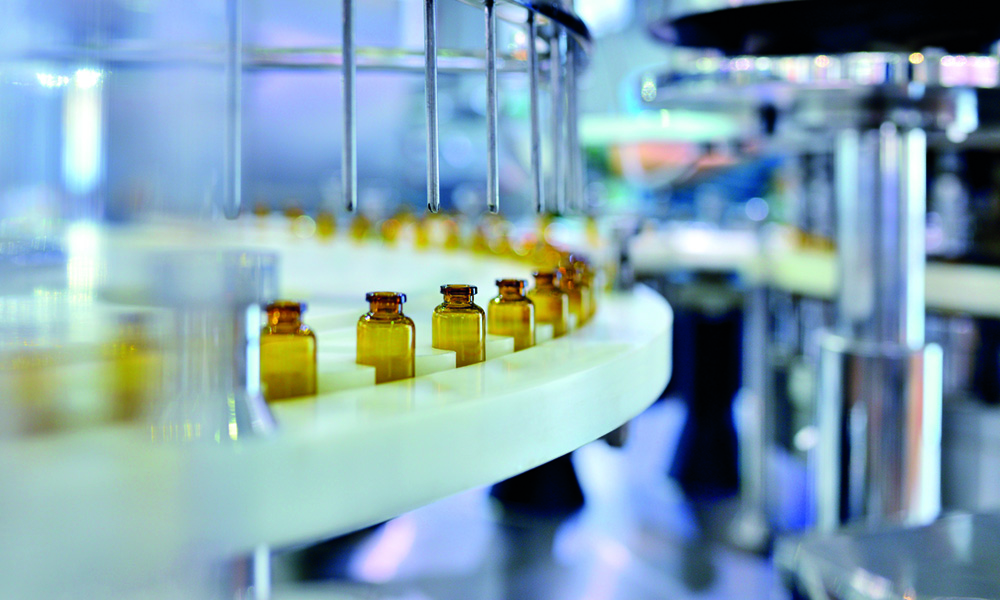 Close-up of brown glass bottle filling at production line